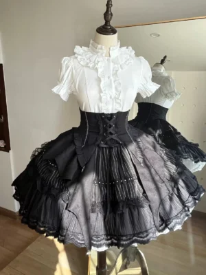 Complete Gothic Lolita outfit displayed on dress form featuring white frilled blouse, lace-up corset waist, and striped gradient black skirt with layered ruffles