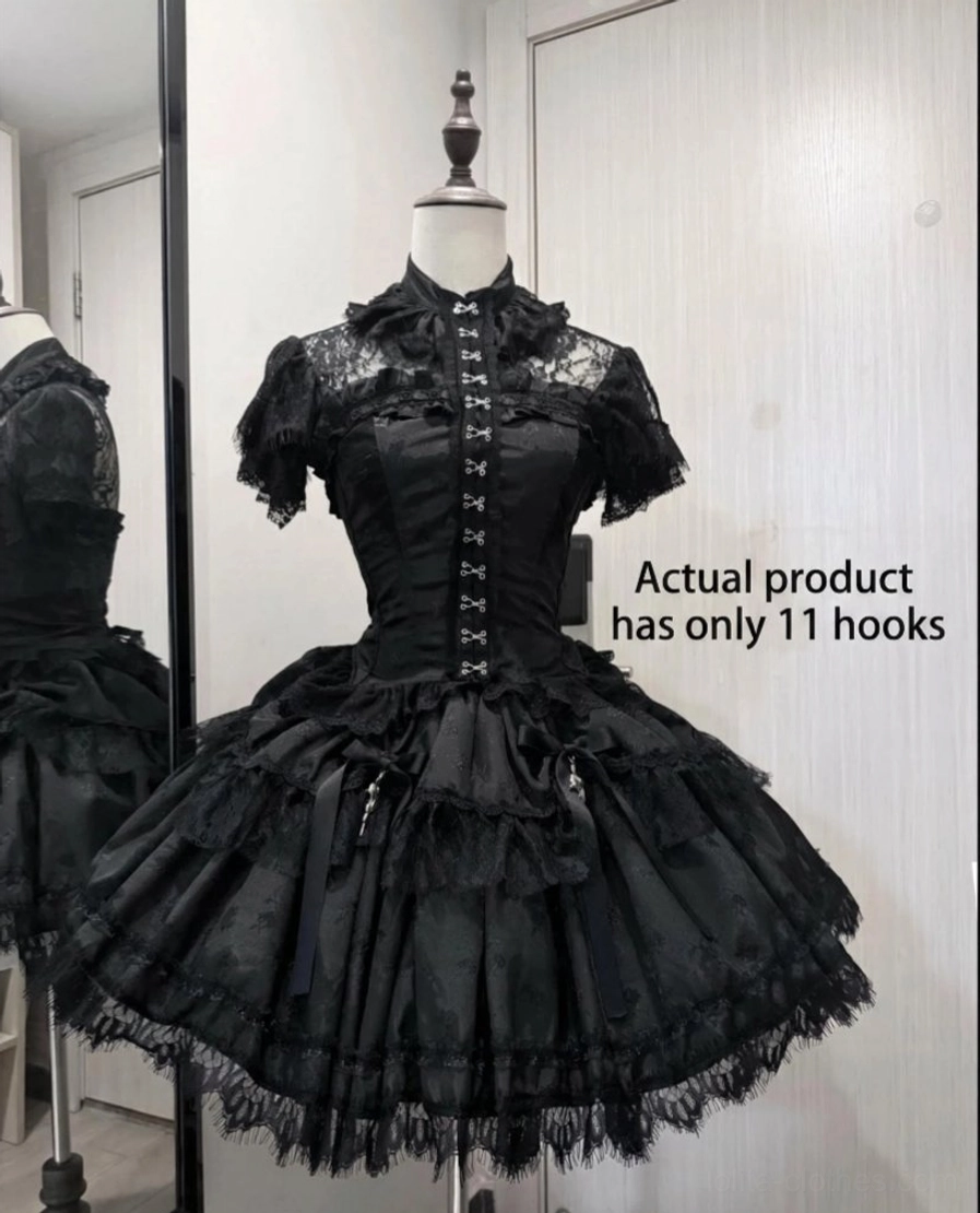 Black gothic lolita corset with short lace sleeves and layered mesh skirt with cross charms and ribbon details, front three-quarter studio view showing 11 hook-and-eye closures detail