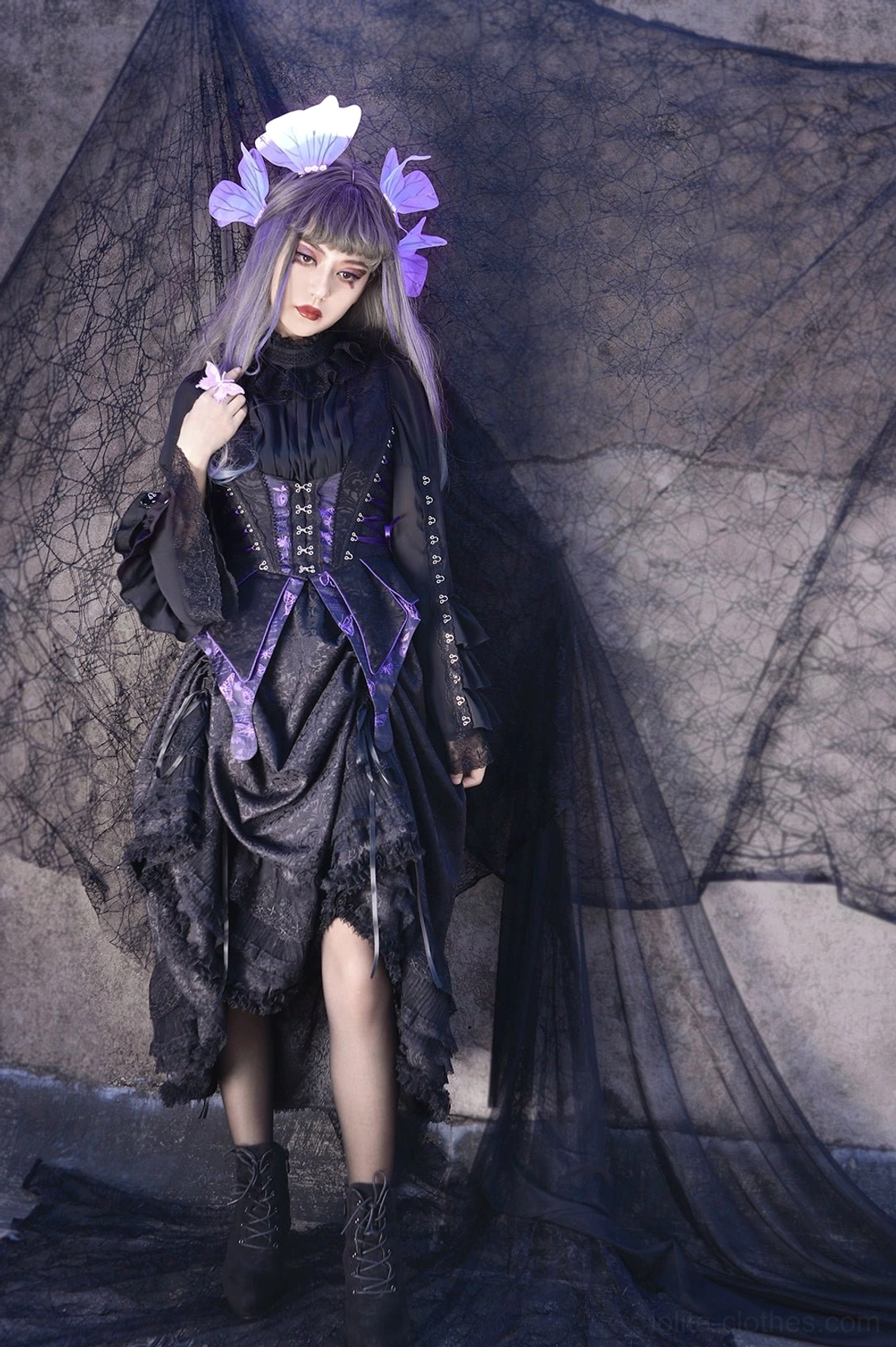 Gothic lolita three-piece set showing angled model view with black fitted corset vest, ruffled bishop sleeve blouse, and flowing tiered lace skirt with decorative details