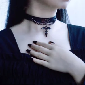 Gothic lolita cross leather choker worn on model with black hair, featuring black leather strap and metal cross pendant with bat wing design
