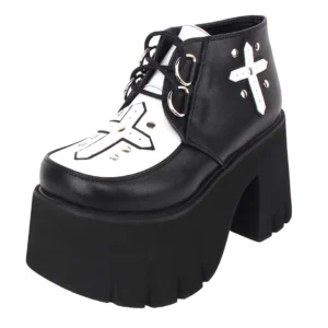 Gothic lolita cross platform boots front three-quarter view showing black and white color blocking with silver stud-studded cross applique and chunky lug platform heel