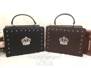 two-tone studded gothic lolita crown handbags flat lay display black and dark brown options metal round studs metallic crown ornament leather top handle white backdrop