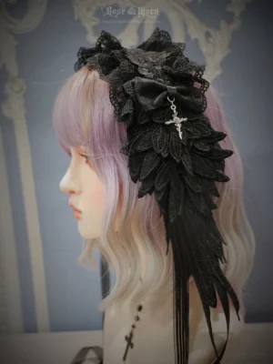 Pure black gothic lolita devil wings headband with silver cross pendant and ruffled lace trim, side profile view showcasing 3D embroidered wing details and hanging tassel