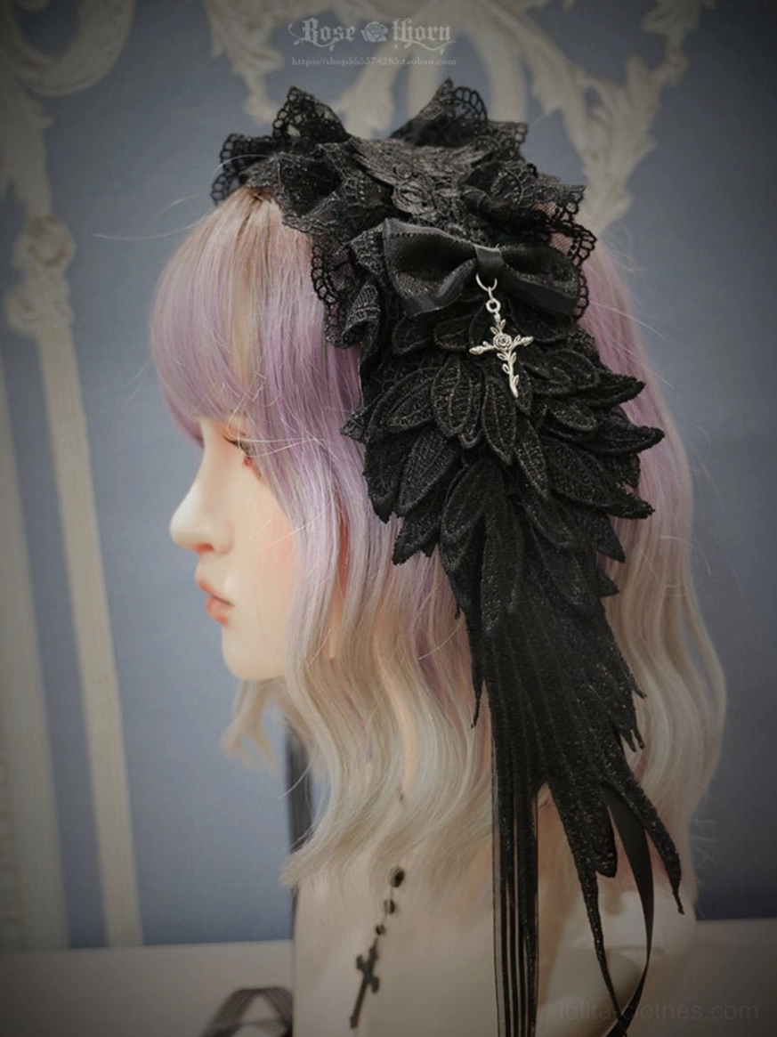 Pure black gothic lolita devil wings headband with silver cross pendant and ruffled lace trim, side profile view showcasing 3D embroidered wing details and hanging tassel