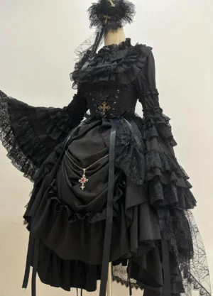 Gothic Lolita black dress displayed on mannequin front view, showing princess-sleeve blouse with multi-layer lace trumpet sleeves, ruffled bust detail, detachable cross pendant strap, asymmetrical high-low hemline with layered ruffles and cincher waist overlay