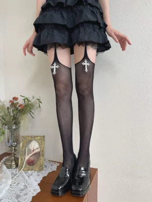 Gothic Lolita black fishnet thigh high pantyhose with silver cross pendant garter strap worn with ruffle tiered skirt and patent leather block heels front view