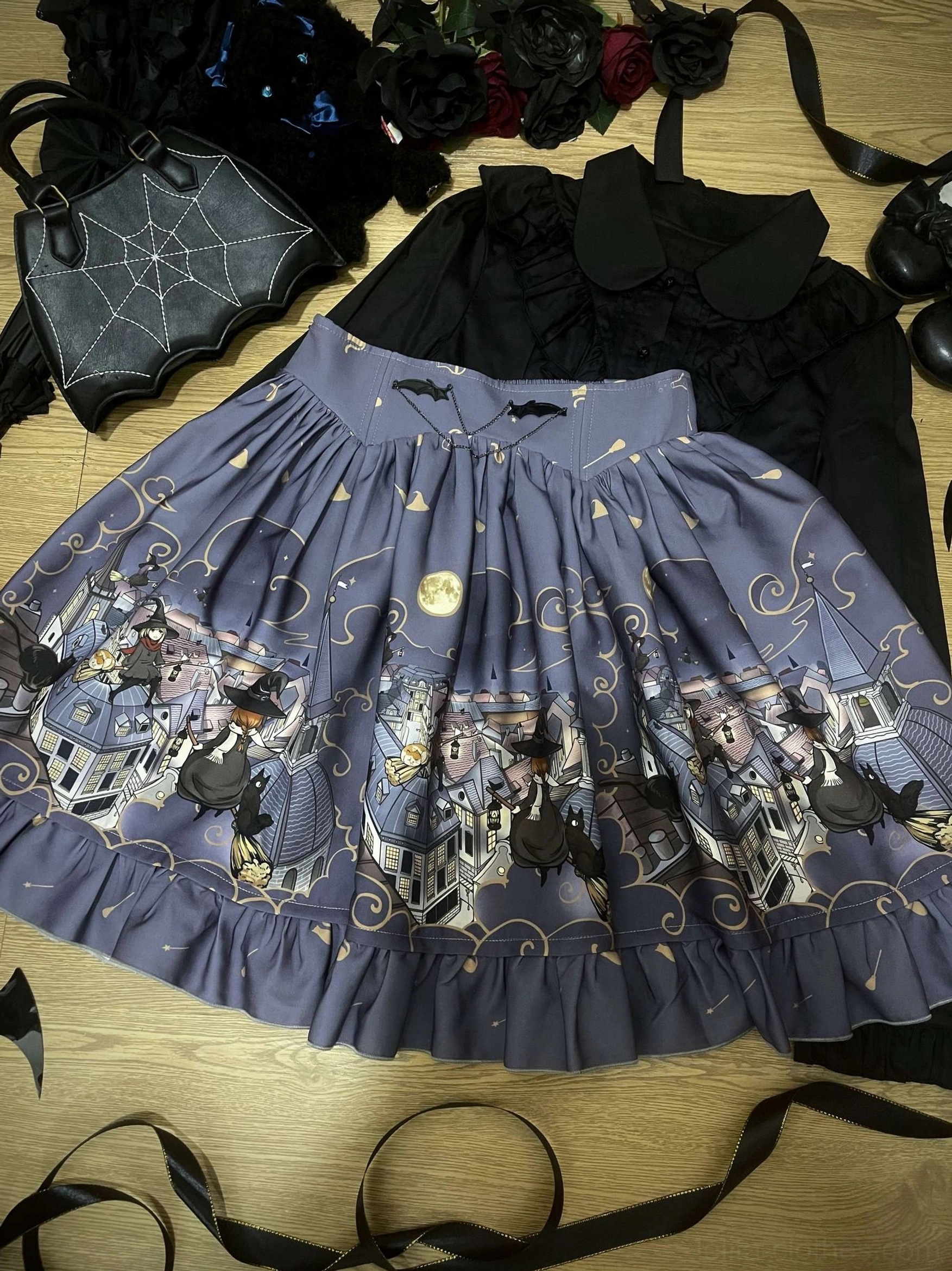 Flat lay top-down view dark navy blue Gothic Lolita Halloween SK skirt with decorative buckles ruffled hem celestial and witch town prints golden vines