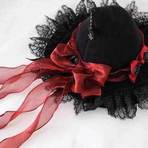 Gothic Lolita Halloween witch hat rear overhead view showing large red satin bow with sheer ribbons, black knit crown, lace trim and small bat brooch charm detail