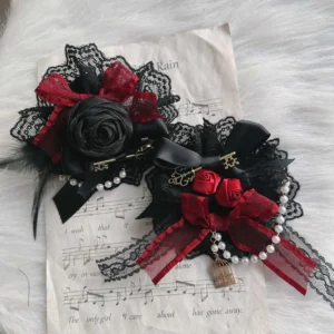 Pair of handmade Gothic Lolita hair ornaments with black red lace, feather accents, rose decoration and vintage key pendants on white fur backdrop