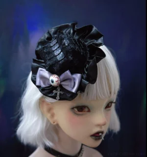 Halloween gothic lolita hair accessory featuring light purple bow with eyeball and cross charm on black ruffled base, front three-quarter view on BJD doll