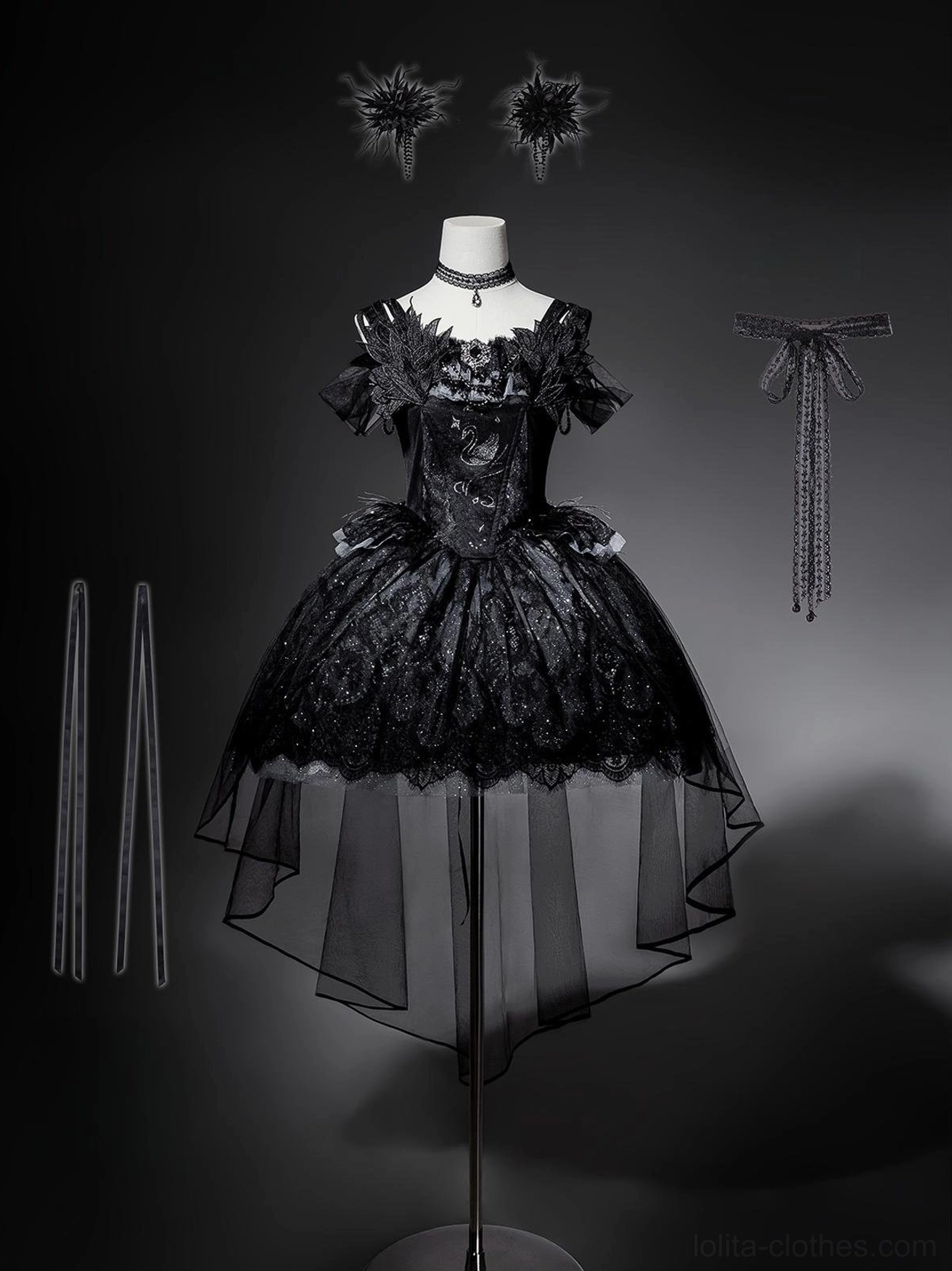 Black gothic lolita JSK dress with matching accessories displayed on mannequin, including feather hair clips, lace-up back ribbon, and dress support straps on dark background