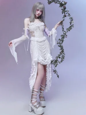 Divine Redemption white gothic lolita jumper skirt with corset bodice, adjustable ruffled hem, detachable lace sleeves, and silver cross pendant - front three-quarter view on model with silver hair and purple floral backdrop