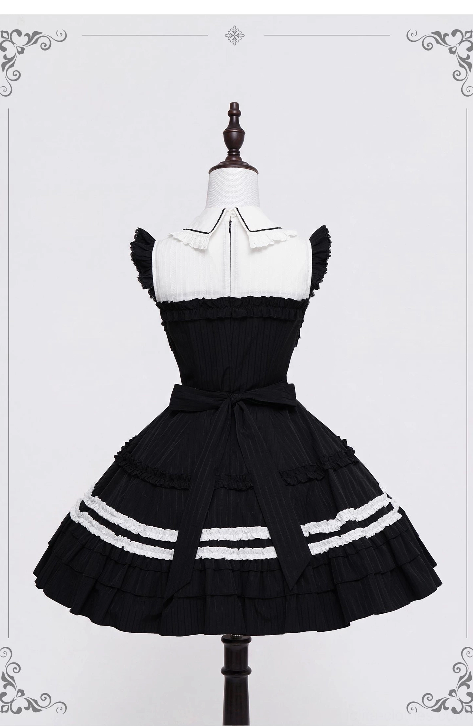 Gothic lolita black white ruffled JSK dress back view showing waist sash bow and open back design on mannequin