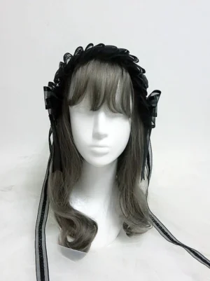 Black lolita KC headband front view on mannequin with ruffled lace design, side bow decorations, and black ribbon tie straps, gothic lolita hair accessory