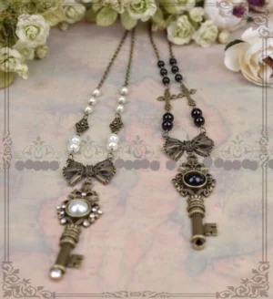 Dual gothic lolita vintage key pendant necklaces with antique bronze finish and pearl gem variants displayed on ornate vintage map background with cream artificial roses