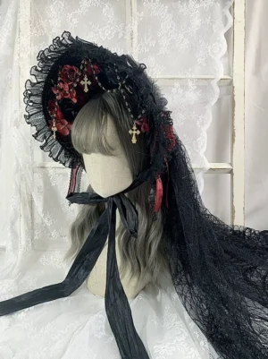 Gothic lolita lace bonnet with black ruffled trim burgundy roses and gold cross pendant chains front three quarter view