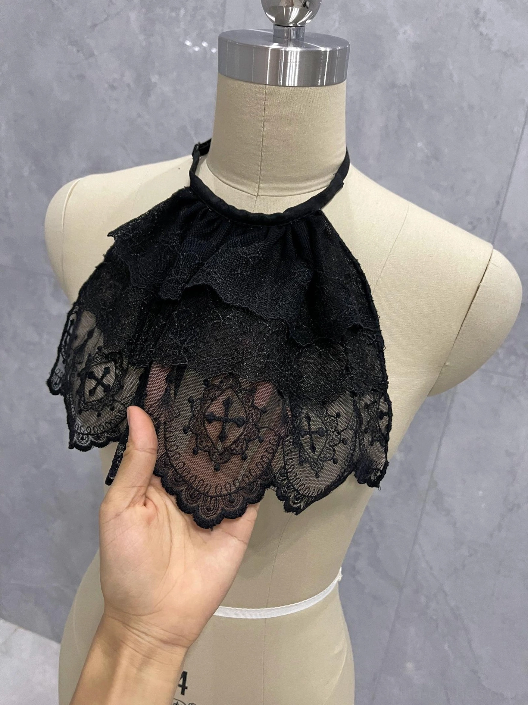Gothic Lolita lace neck bib with layered ruffles and adjustable neckline shown as an elegant dark fashion accessory