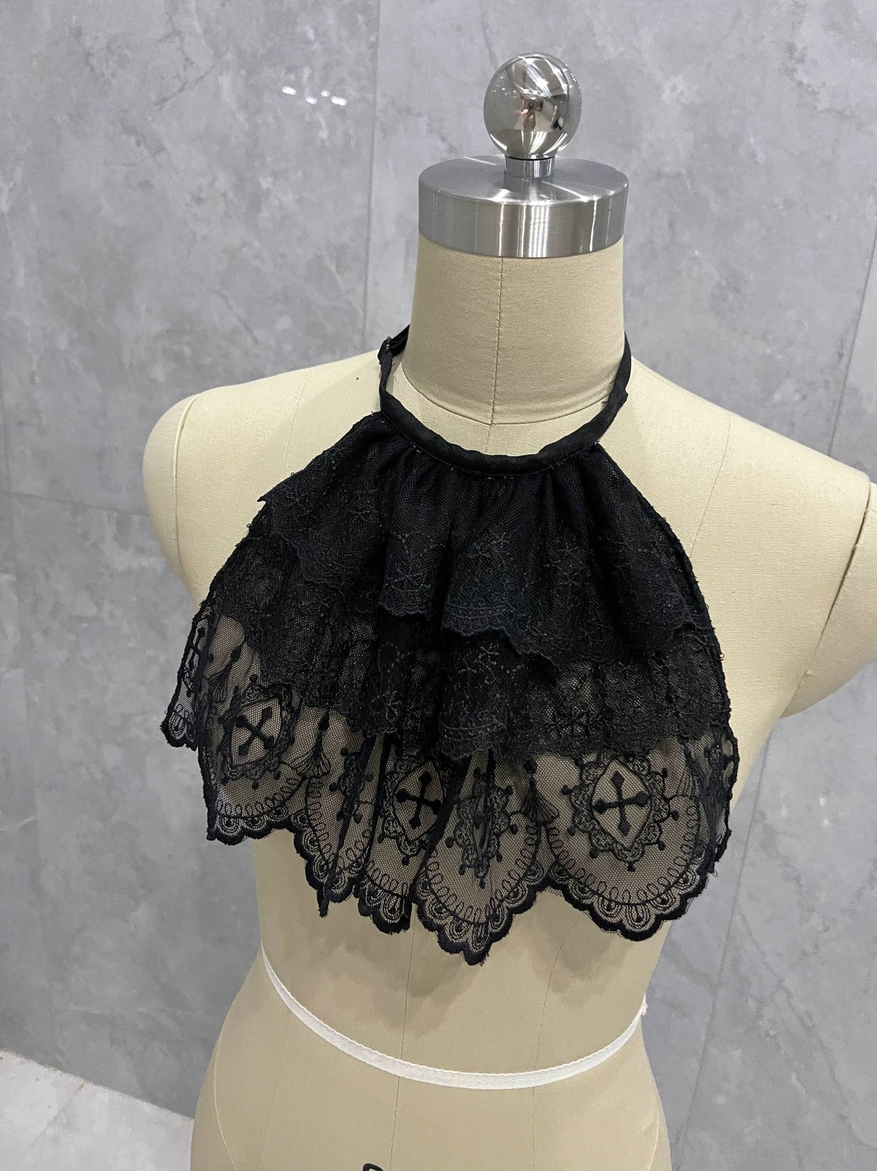 Black layered lace Gothic Lolita neck bib accessory close-up showing the romantic ruffled collar silhouette
