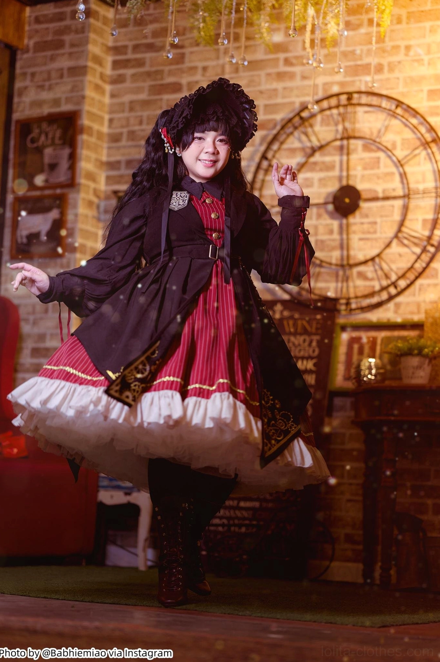 Full body front view of gothic lolita female model wearing dark dress with extreme fluffy white petticoat underneath, creating voluminous bell silhouette, vintage brick wall studio