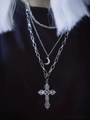 front close-up view of triple-layer gothic lolita metal chain necklace on neck and upper chest area showing thin choker layer with crescent pendant and thick link chain with large carved cross detail