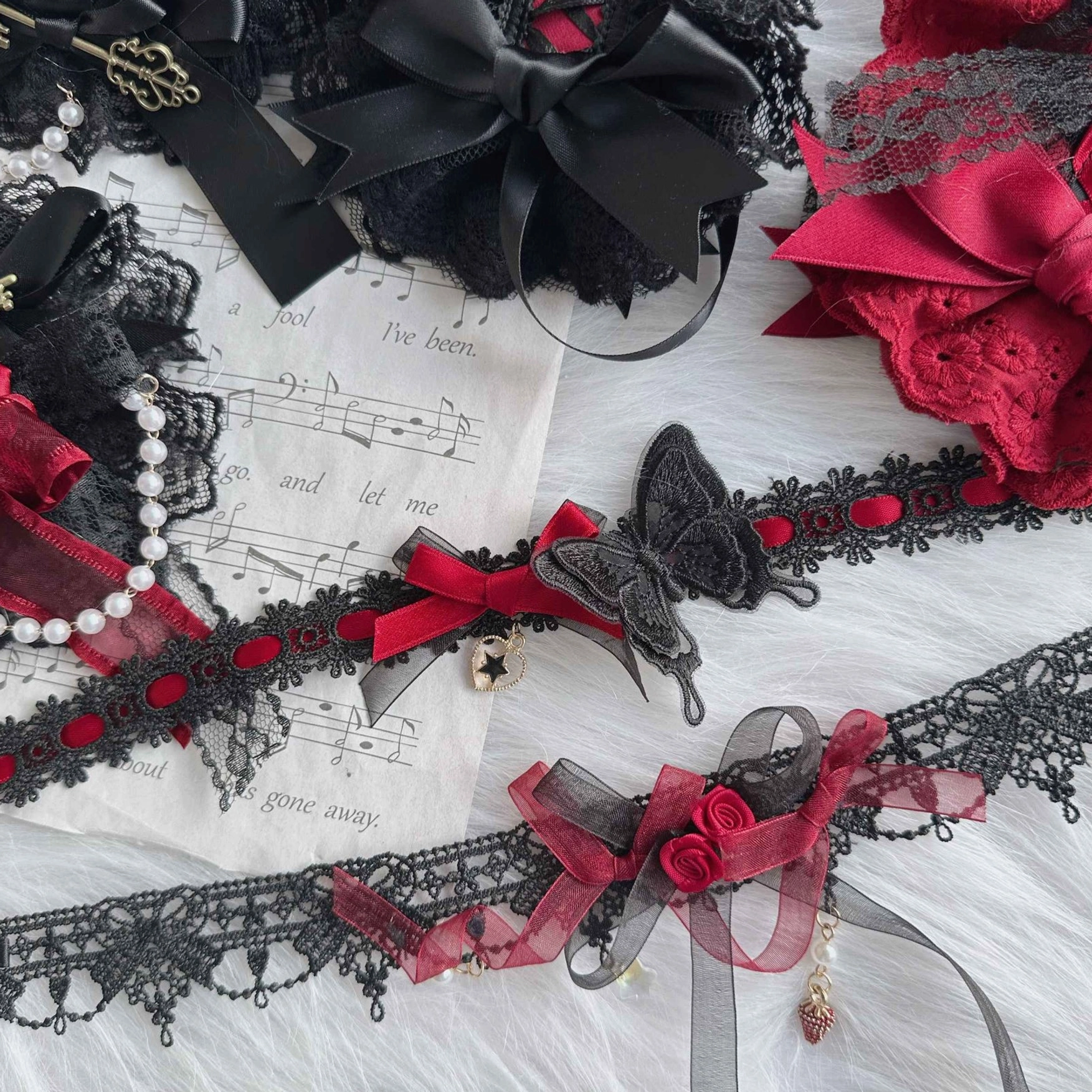 Multiple Gothic Lolita necklace and hair accessory styles including black lace chokers, red satin bows, butterfly decor, bell pendants and rose embellishments