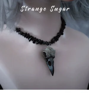 Gothic lolita choker with obsidian beaded chain and silver vintage bird skull pendant worn on mannequin with silver grey wig, front close-up neck view showing dark romantic aesthetic