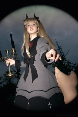 Bat-inspired gothic lolita OP dress front low angle shot model in dark forest with candelabra prop devil horn accessories