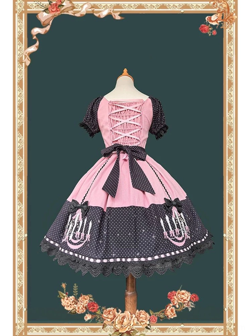 Back full view of pink and black gothic lolita OP dress with off-the-shoulder ruffled sleeves, lace-up corset back, large black waist bow, and scalloped skirt trim
