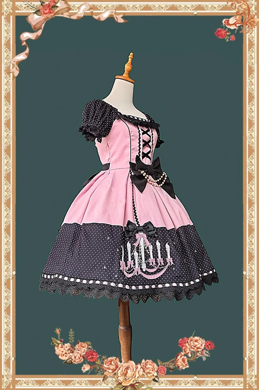 Gothic lolita OP dress showcasing pink and black two-tone design with off-the-shoulder ruffled sleeves, lace-up corset front, and chandelier prints on polka dot skirt with scalloped trim