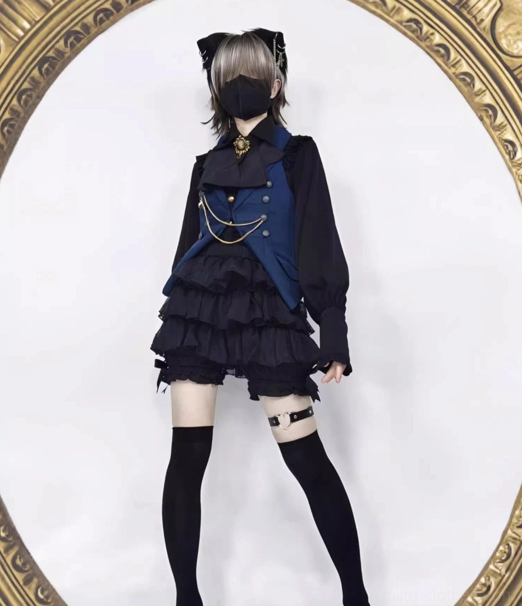 Gothic ouji lolita male model side profile view wearing black tiered ruffle shorts thigh-high socks and heart-shaped leg garter accessories in dramatic gothic prince aesthetic