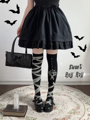 Side view of gothic lolita over-knee socks featuring crisscross straps and scissors design detail on model wearing dark lolita fashion ensemble