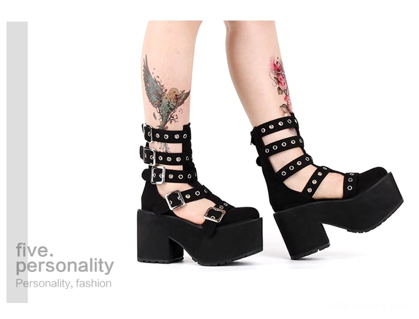 Full lower leg view of tattooed model wearing Gothic punk platform gladiator boots with floral tattoos, showcasing polished patent leather upper and multiple adjustable buckle straps