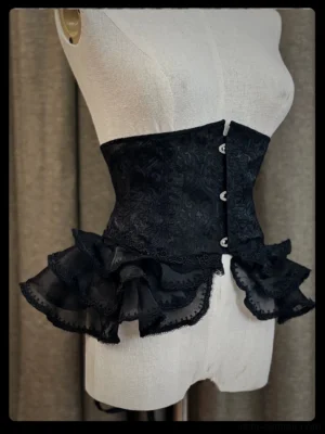 Plus size gothic lolita black fishbone waist cincher with layered tulle flounce front view on dress form mannequin showcasing jacquard damask fabric and hook-and-eye closures