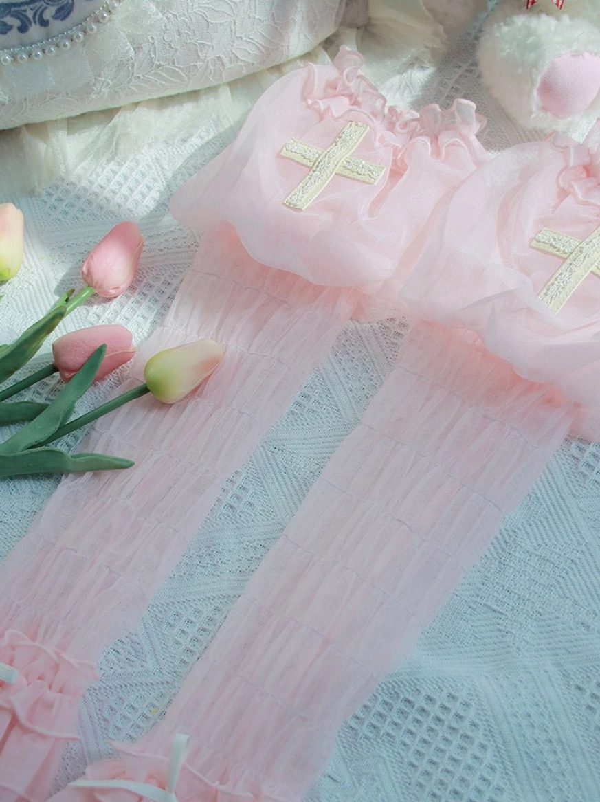 Pink Gothic Lolita puff arm sleeves with cross embroidery and satin ribbon bows, displayed with tulips and plush accessories on soft fabric backdrop