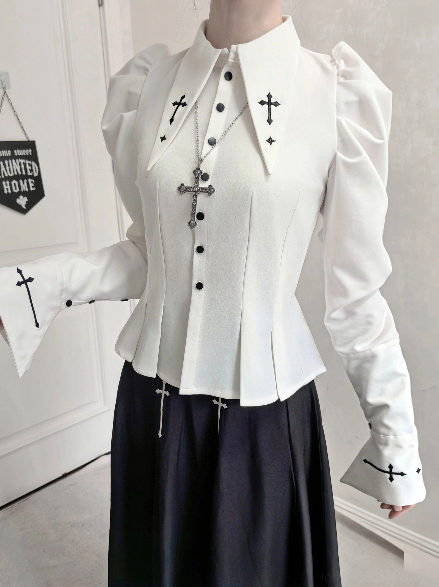 Close-up front view of gothic lolita puff-sleeve blouse with cross embroidery on collar and cuffs, structured sleeves and black JSK