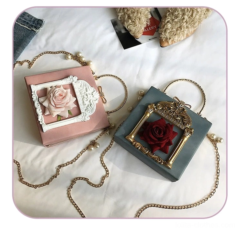 Pink and dusty blue gothic lolita square crossbody bags with carved baroque frame and silk flower embellishment displayed on white bedding