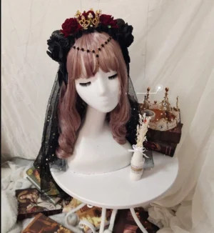 Gothic Lolita rose crown headdress with black tulle veil and dark red roses front three-quarter view on mannequin with curly pink wig