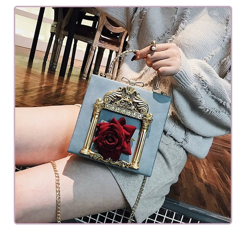 Dusty blue gothic lolita square crossbody bag with red rose and gold baroque frame detail worn with light blue knit sweater indoor styling