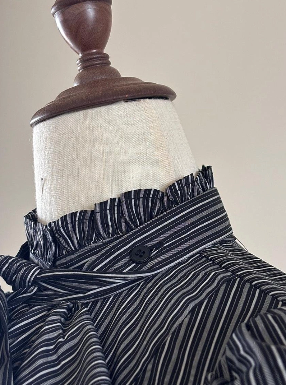 Lifestyle photograph of Gothic Lolita fashion enthusiast wearing striped blouse in authentic daily wear setting demonstrating practical wearability of blouse in real-world context