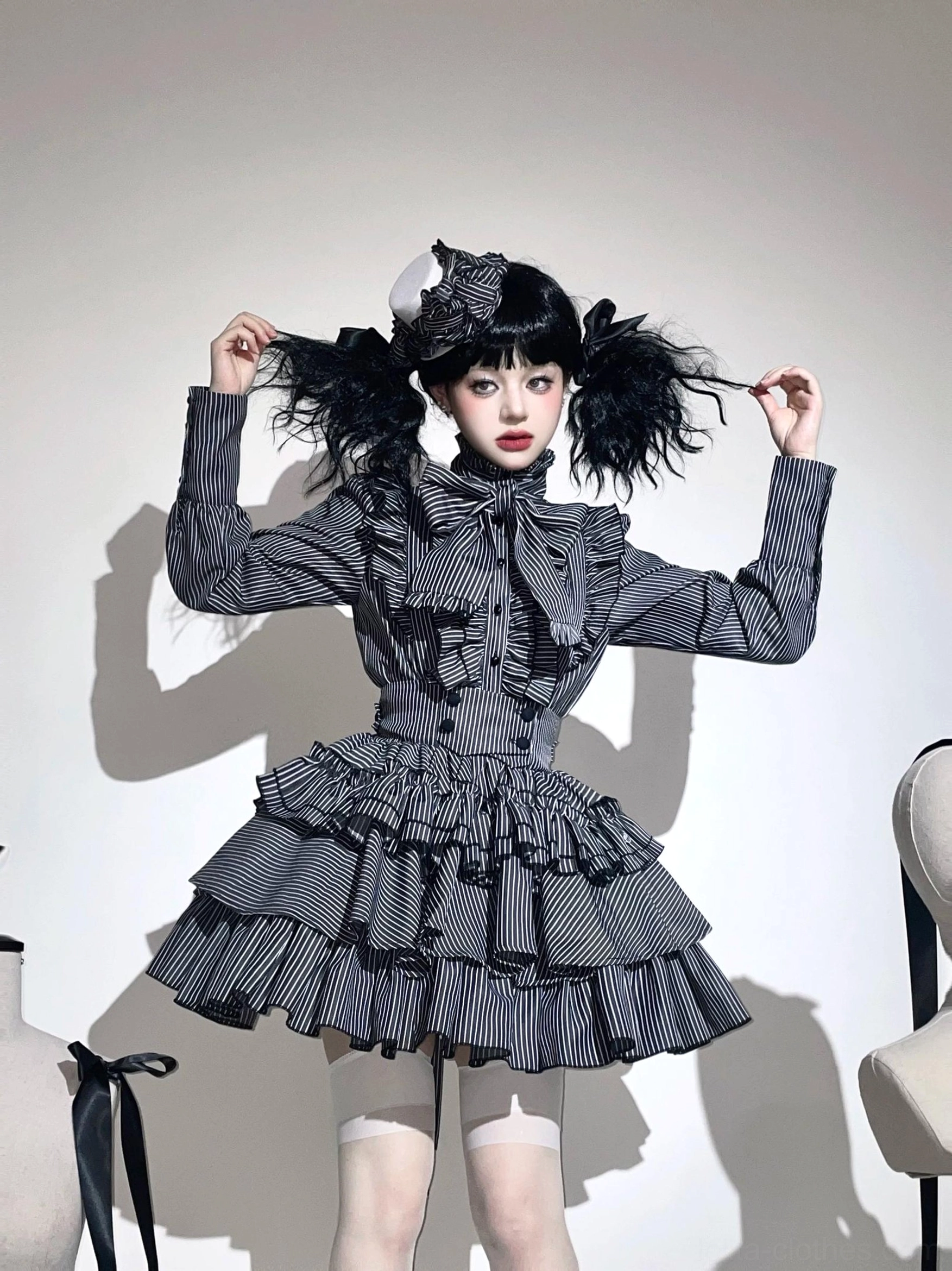 Front view of gothic lolita striped blouse and skirt set with dark grey and white vertical stripes, model wearing twin curly ponytails and hair accessory