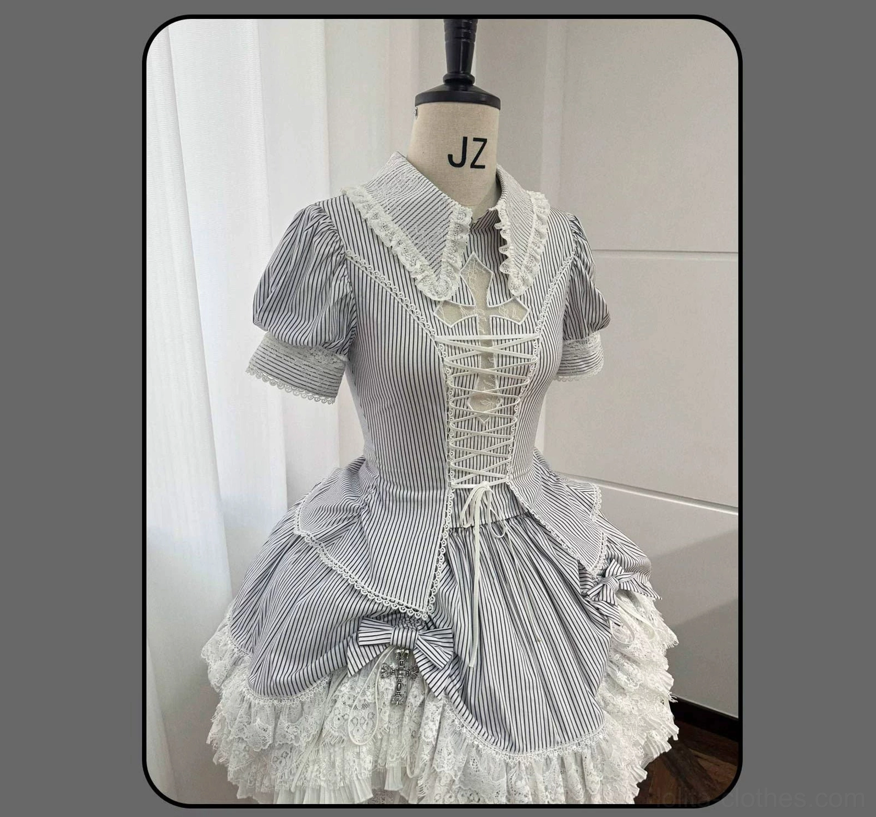 Full-body back shot of striped Gothic Lolita coordinated set showing blouse and tiered skirt architectural construction