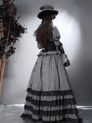 Gothic lolita set back view showing lace-up corset and multi-layered ruffled skirt hem with dark botanical backdrop