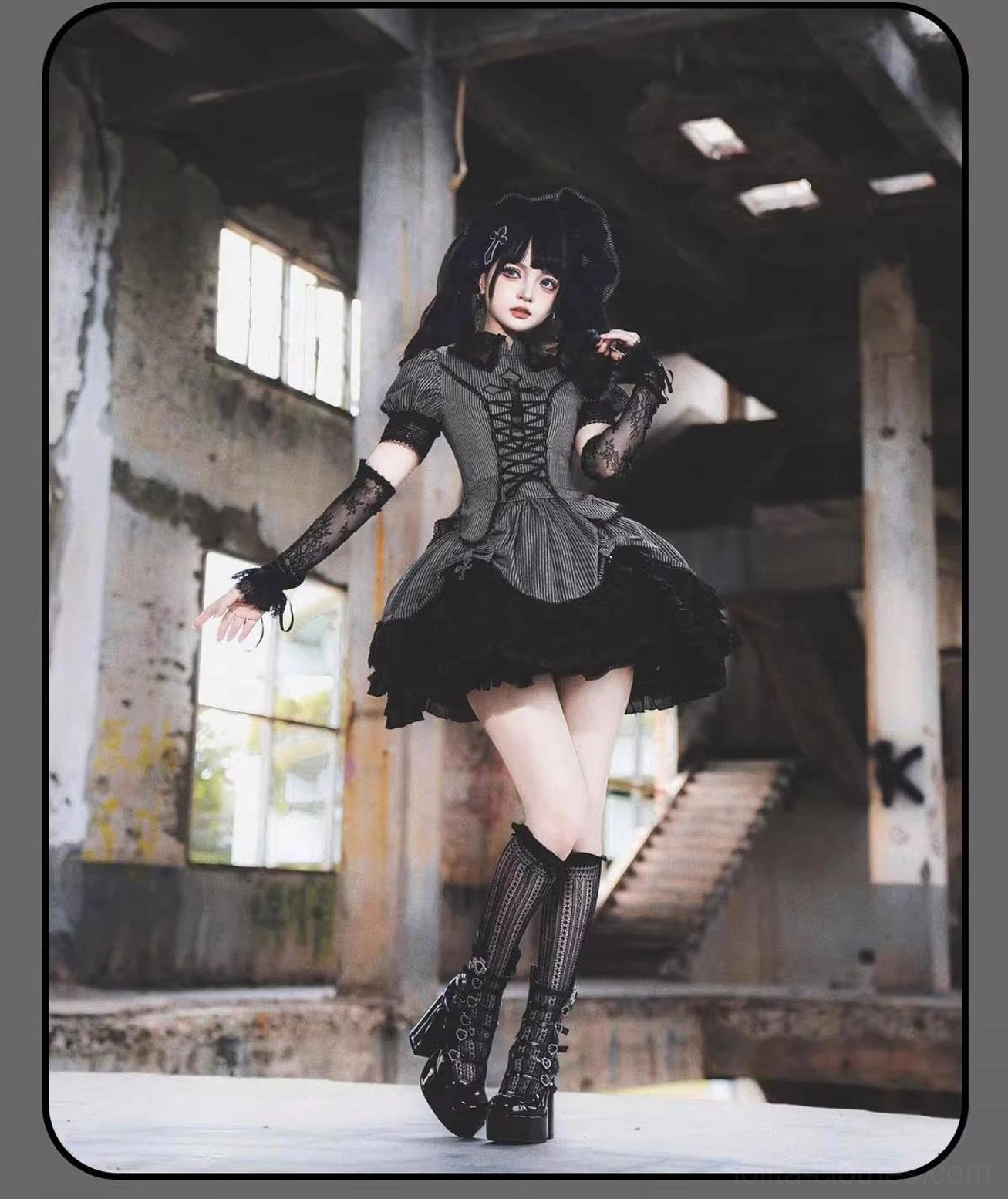 Dark striped Gothic Lolita blouse and skirt set with lace gloves and platform boots, low-angle full-body side shot in abandoned industrial setting