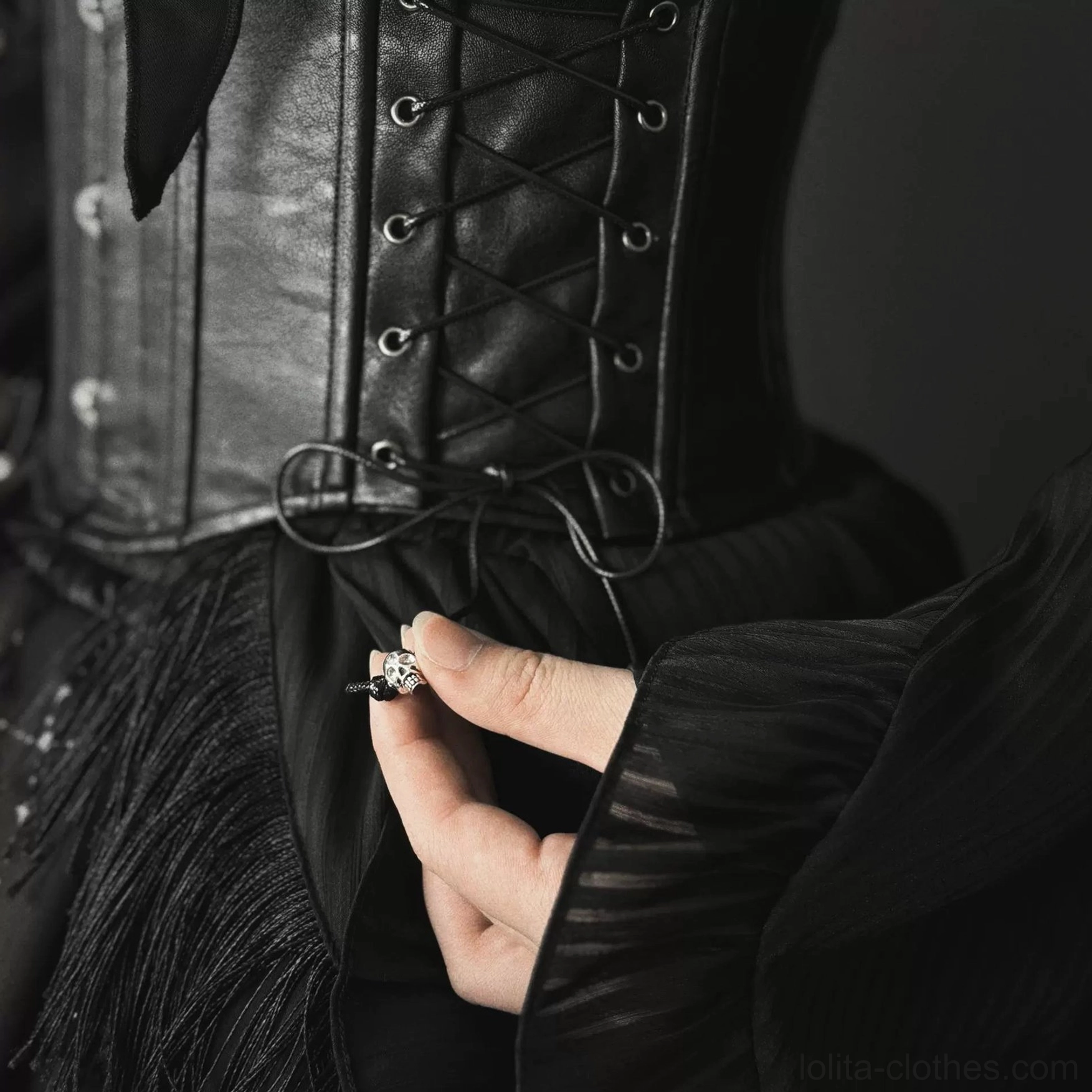 Close-up detail shot of Gothic Lolita corset side lace-up adjustment straps with matte faux leather and metal studs decorations