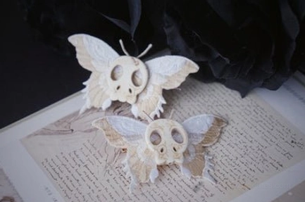 White skull moth lolita hair clips with white fabric moth wings and skull charm on vintage paper dark flower decorations