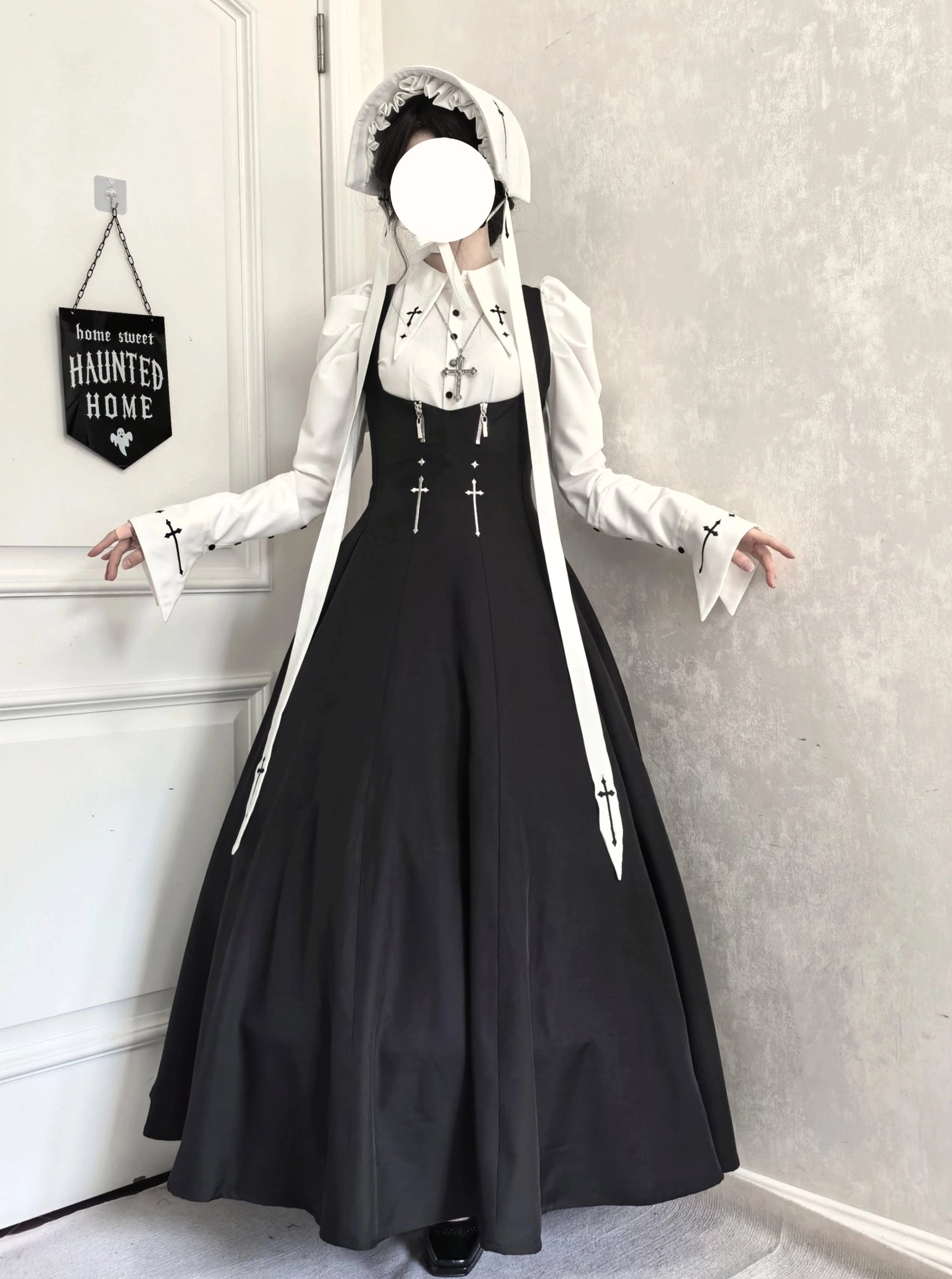 Full-body front view of gothic nun lolita JSK coordinate set with black-and-white color scheme, cross embroidery details, and nun headwear at indoor doorway