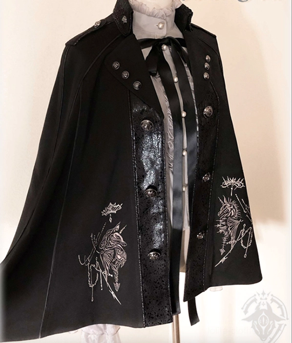 Back view half-body display of Gothic Ouji black embroidered cape on mannequin with matching inner coordinate, rear silver embroidery pattern, metal stud shoulder decorations and bow tie