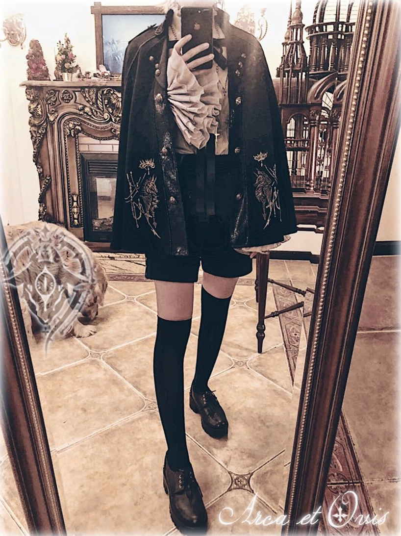 Full-body Gothic Ouji Lolita coordinate set in vintage European room mirror view featuring black cape, matching jacket with silver embroidery, shorts, knee-high socks and leather shoes