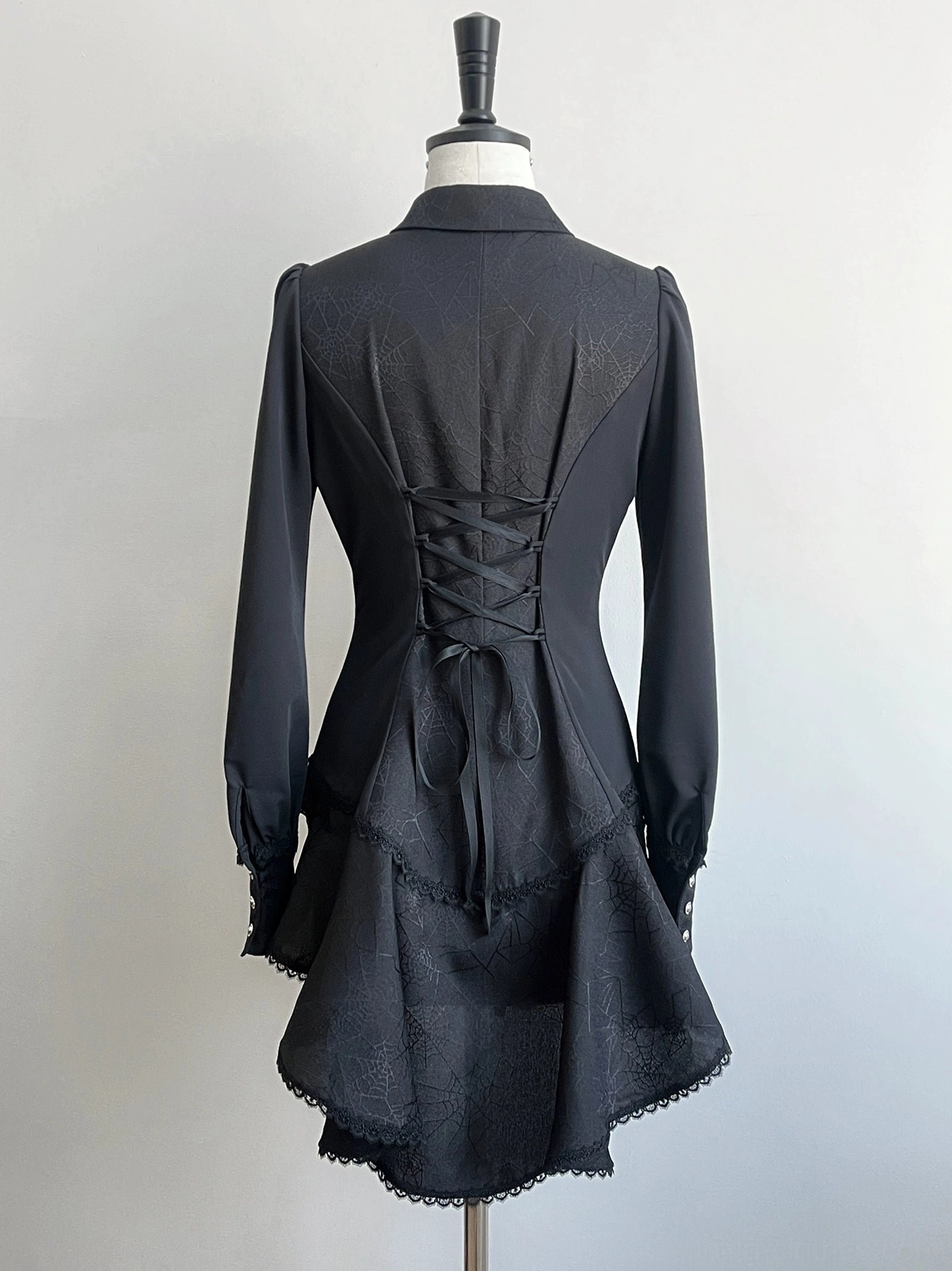 Black gothic Ouji lolita spiderweb shirt back view on dress form showing lace-up corset back design and high-low scalloped hemline