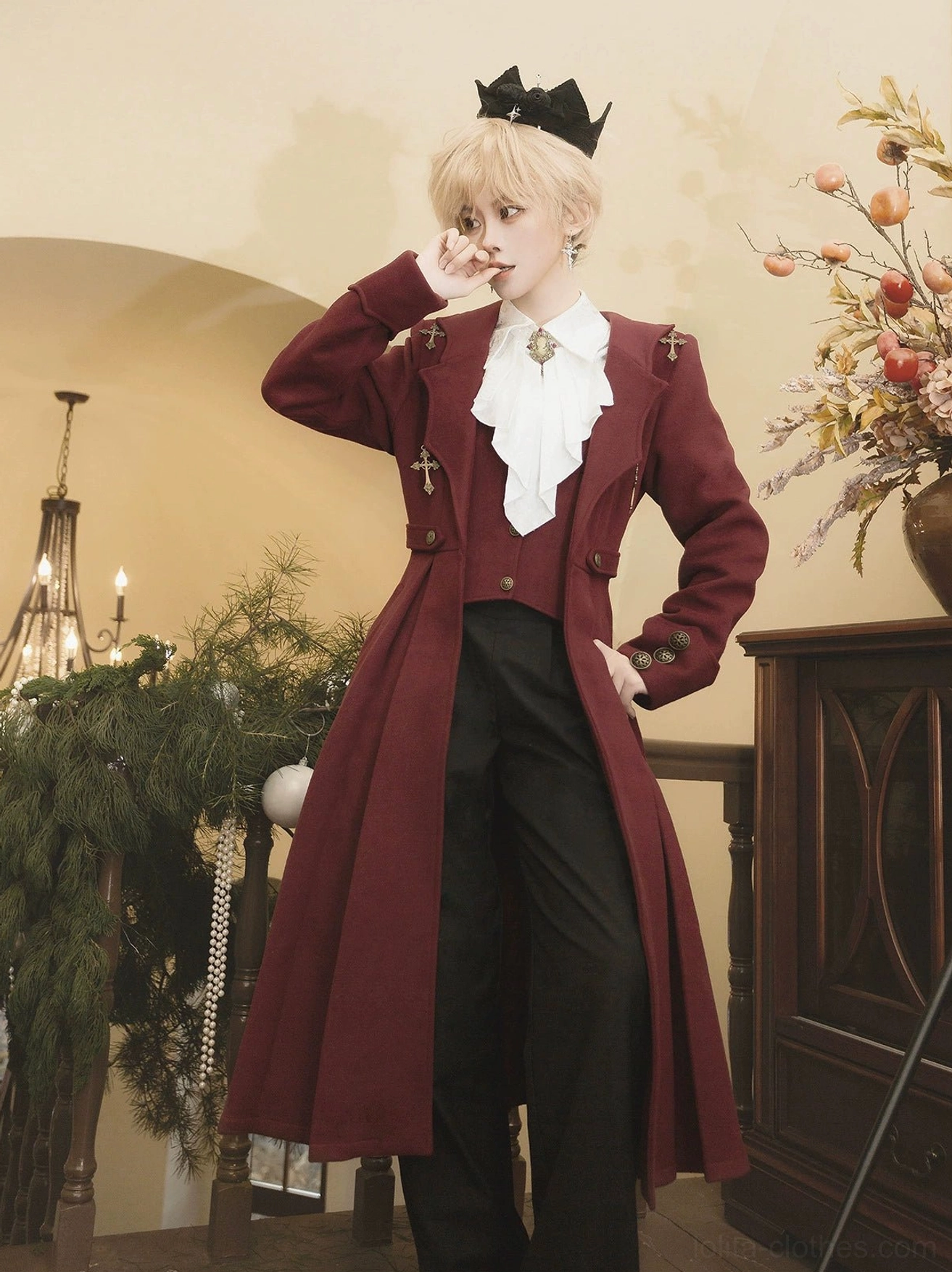 Gothic Ouji Lolita Winter Coat Set front three-quarter view on androgynous model wearing burgundy velvet tailored coat with white ruffled jabot and cross brooch in vintage villa with chandelier